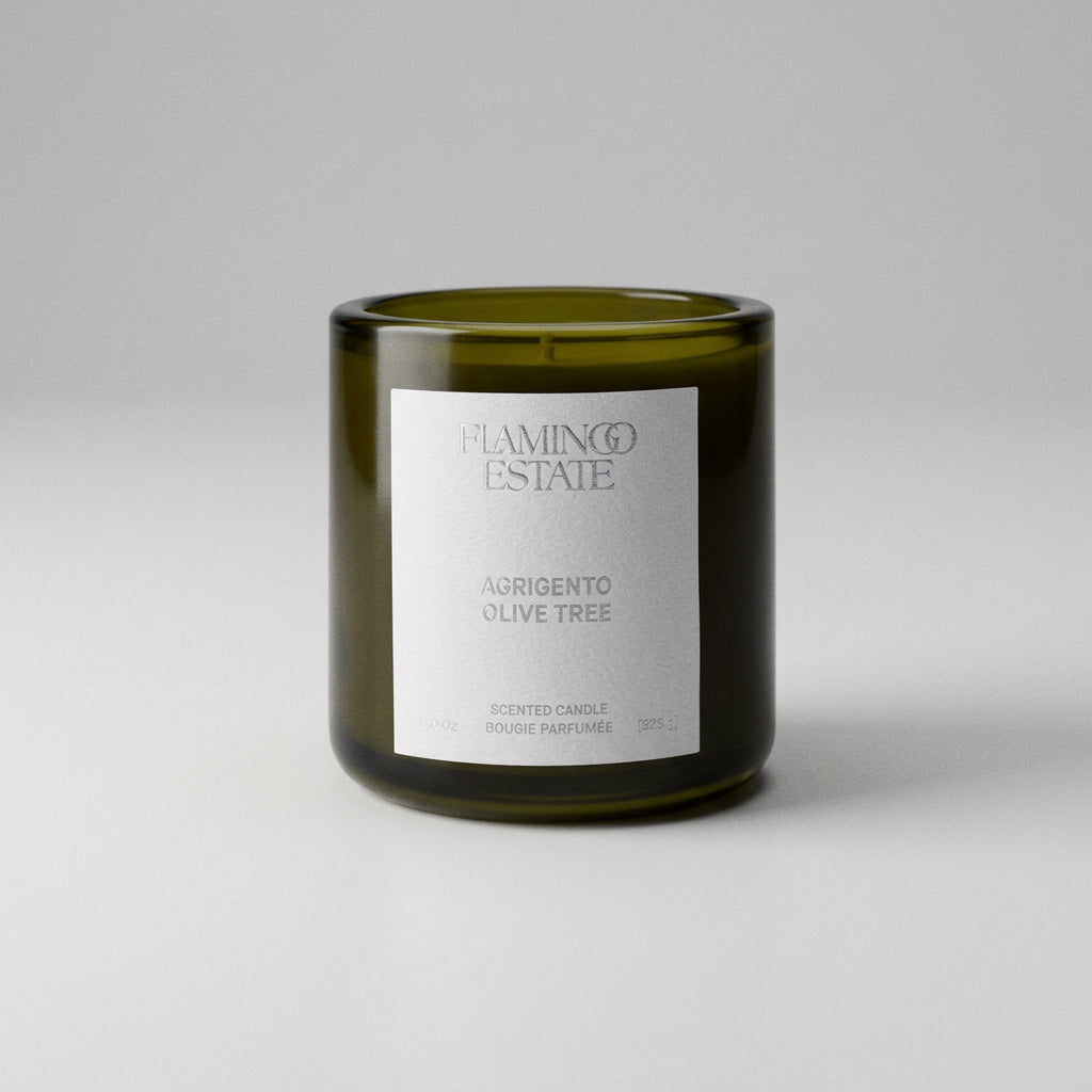 Green candle with a white label on a white background